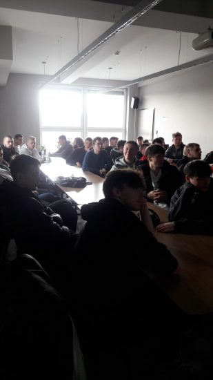 Grupa uczniów w sali konferencyjnej.