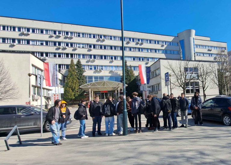 Grupa uczniów przed budynkiem sądu.