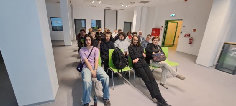 Grupa uczniów w sali konferencyjnej. 